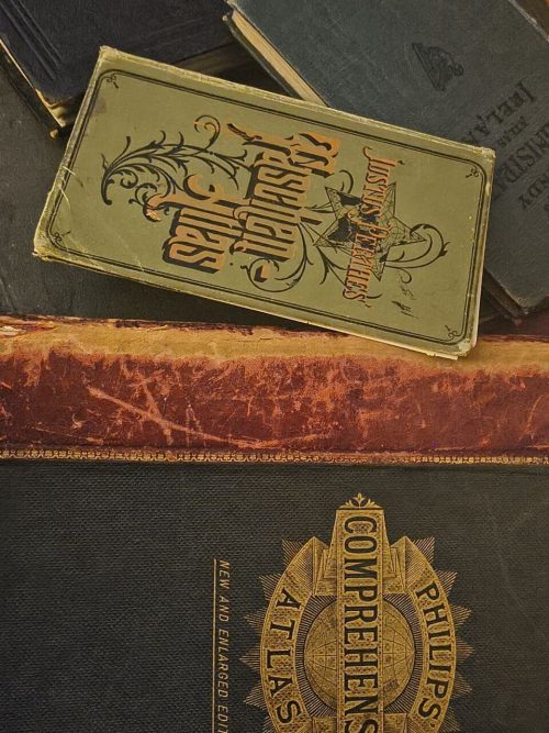 Vintage atlas book cover with detailed map illustrations and classic typography.